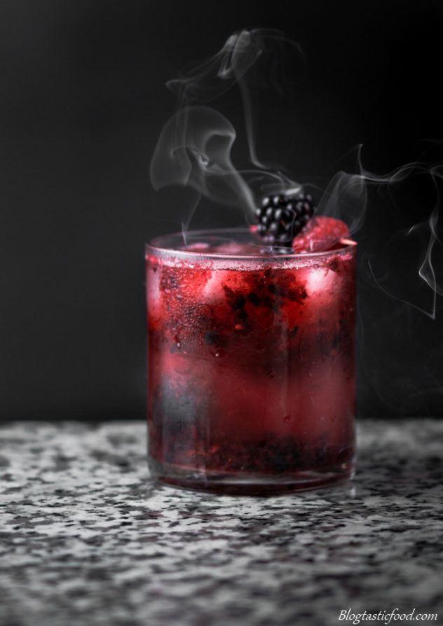 A Black Widow cocktail with smoke in the background. 