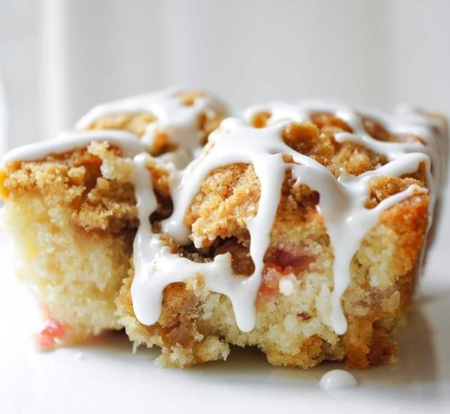 A frontal view of strawberry coffee cake with icing drizzled on top.