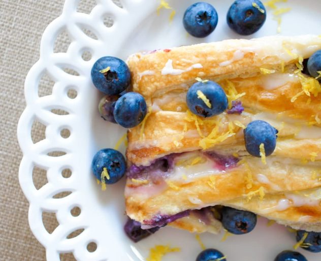 An overhead photo of a blueberry danish with mascarpone on a white plate. 