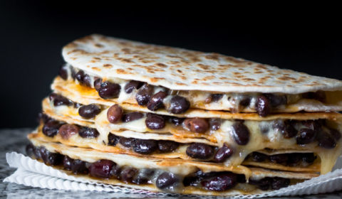cheesy black bean quesadillas stacked on top of each other.