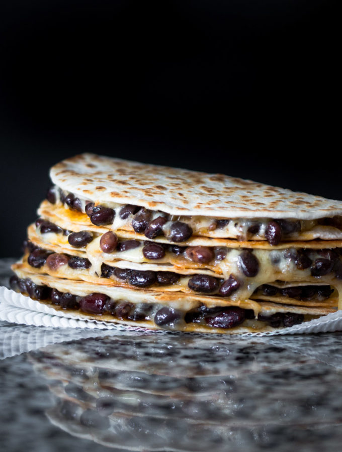 cheesy black bean quesadillas stacked on top of each other.