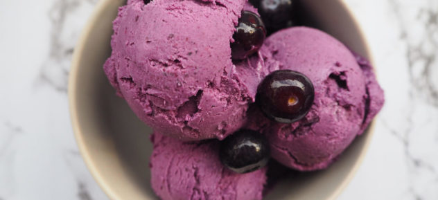 An overhead photo of vegan blueberry and cashew ice-cream served in a small white bowl.