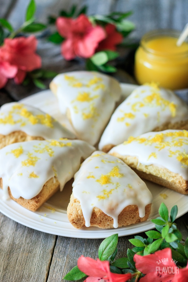 6 lemon scones served in a circle on a white plate, garnished with lemon zest. 