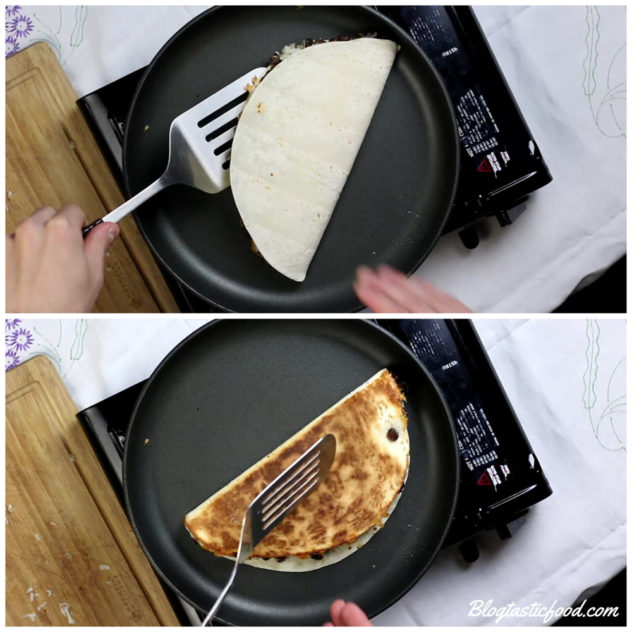 a black bean quesadilla that is toasting in a pan getting flipped.