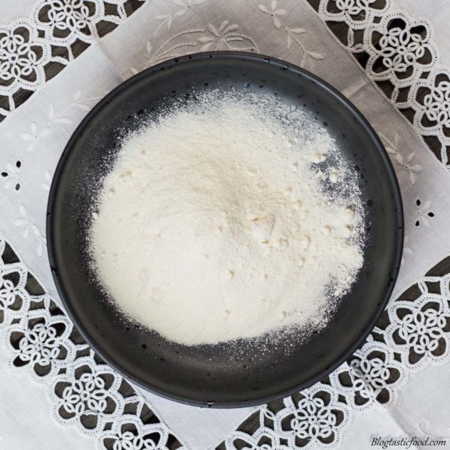 An overhead shot of coconut flour in a black bowl.