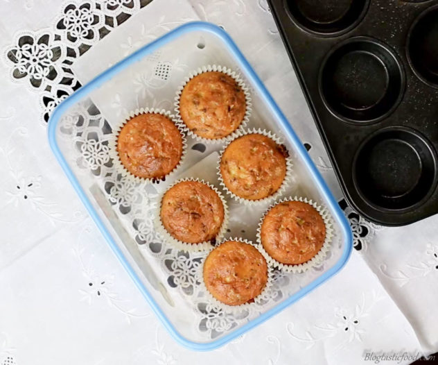 An overhead photo of 6 bacon breakfast muffins stored in a container.