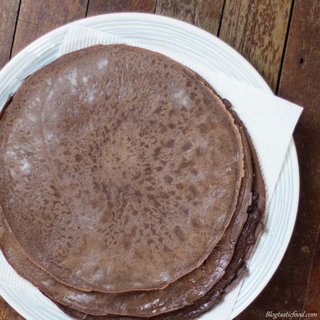 Stack chocolate crepes on a plate with kitchen paper.
