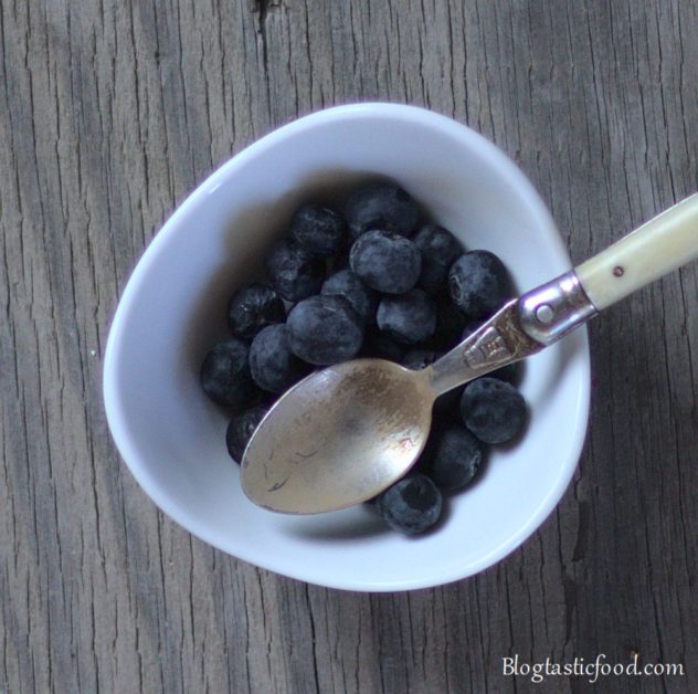 Blueberries and a small spoon in a mini bowl.