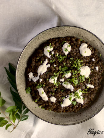 Lentil curry served in a bowl, garnished with sour cream and coriander.