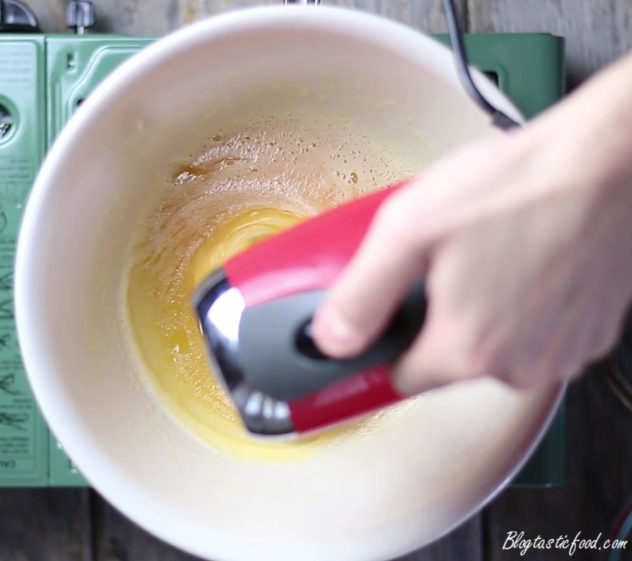 A sugar and egg mixture being beaten over a water bath.